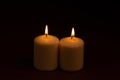 Two whiteÃÂ candlesÃÂ flameÃÂ burningÃÂ onÃÂ dark backgroundÃÂ withÃÂ copyÃÂ space forÃÂ text Royalty Free Stock Photo
